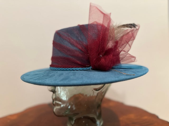 Blue vegan suede fedora hat with fabric flowers and an overlay of cranberry netting! Feel sharp and frisky!
size L
$149.00